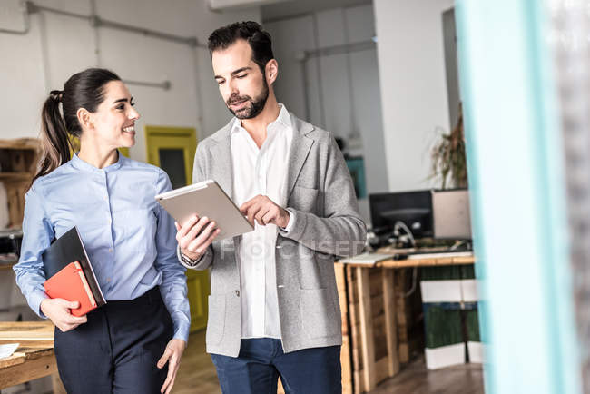 Man and woman walking in office and discussing. — Stock Photo