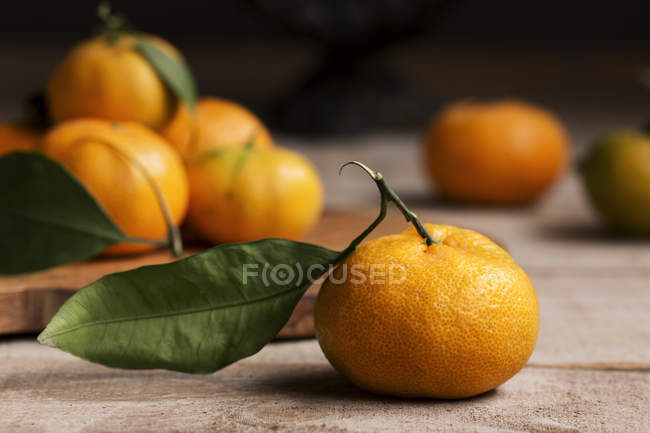 Fresh tangerines over wooden table — Stock Photo