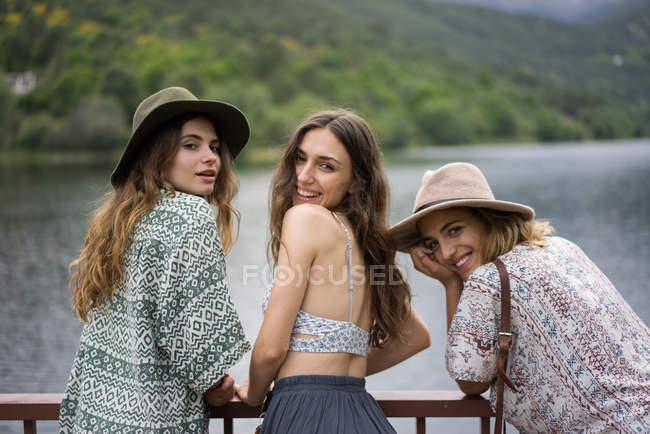 Amies gaies posant sur le pont — Photo de stock
