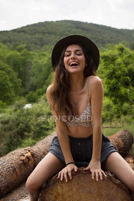 Ragazza sorridente posa su log — Foto stock