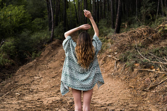 Back view of hipster girl in forest — Stock Photo