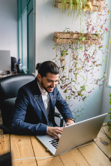 Portrait en grand angle d'un homme d'affaires tapant un ordinateur portable sur son lieu de travail . — Photo de stock