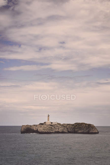 Lighthouse over rocks on island — Stock Photo
