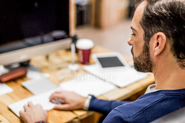Thoughtful businessman using PC at office workplace — Stock Photo