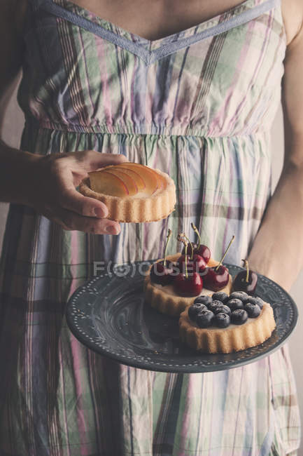 Женщина держит сладкие торты — стоковое фото
