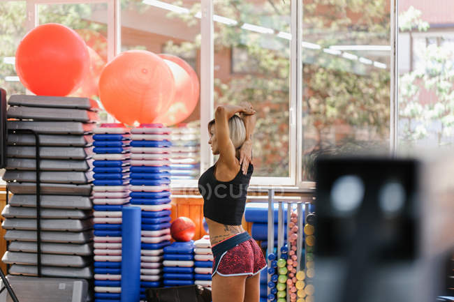 Mujer atlética estirándose en Gimnasio - foto de stock