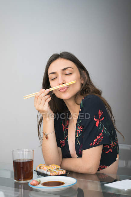 Zufriedene Frau posiert mit Essstäbchen — Stockfoto