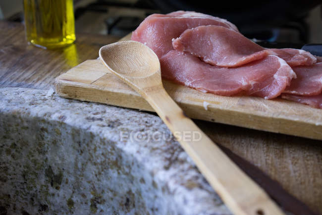 Carne en rodajas sobre tabla de madera - foto de stock