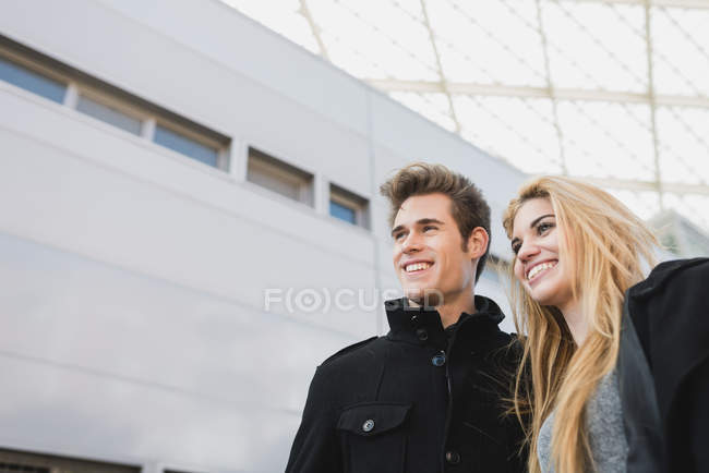 Low angle portrait of couple walking out of office building. — Stock Photo