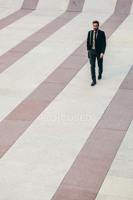 Бизнесмен шагает по полосатому полу — стоковое фото
