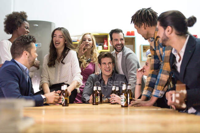 Riendo gente con cerveza en la fiesta de la oficina - foto de stock
