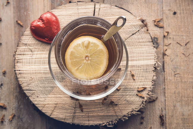 Tea with lemon and chocolate red heart — Stock Photo