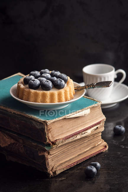 Черничный пирог поверх старых книг — стоковое фото