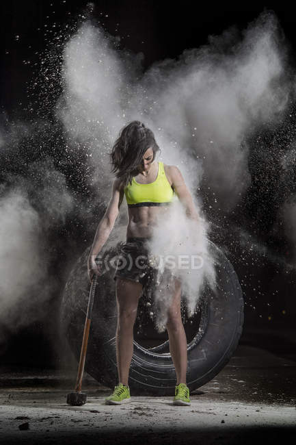 Female in sportive outfit holding big hammer — Stock Photo