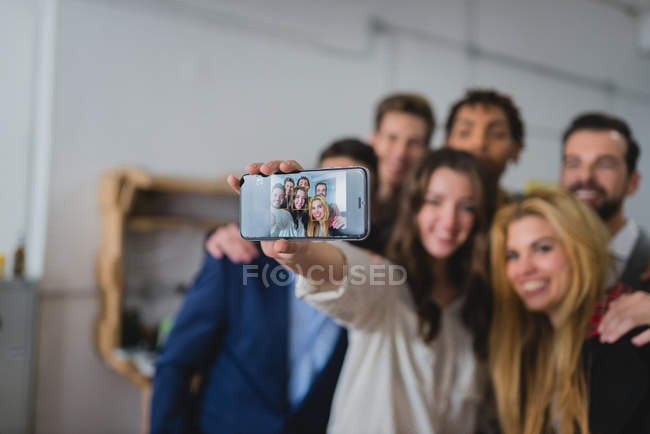 Retrato del grupo de empresarios tomando selfie con cámara de smartphone en la oficina . - foto de stock