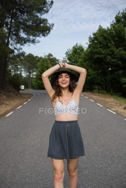 Modelo alegre posando na estrada — Fotografia de Stock