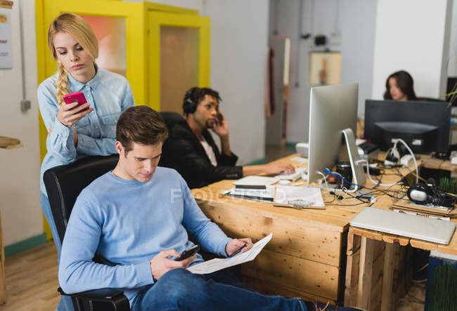 Büro-Szene von Geschäftsleuten, die Geräte am Arbeitsplatz verwenden — Stockfoto