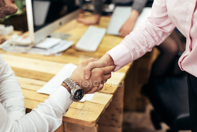 People at the meeting holding hands. Horizontal indoors shot. — Stock Photo
