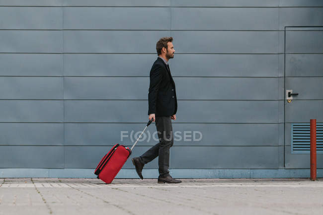 Empresario con una maleta roja - foto de stock