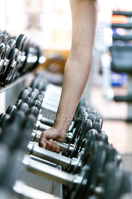 Mujer tomando pesas en el gimnasio - foto de stock