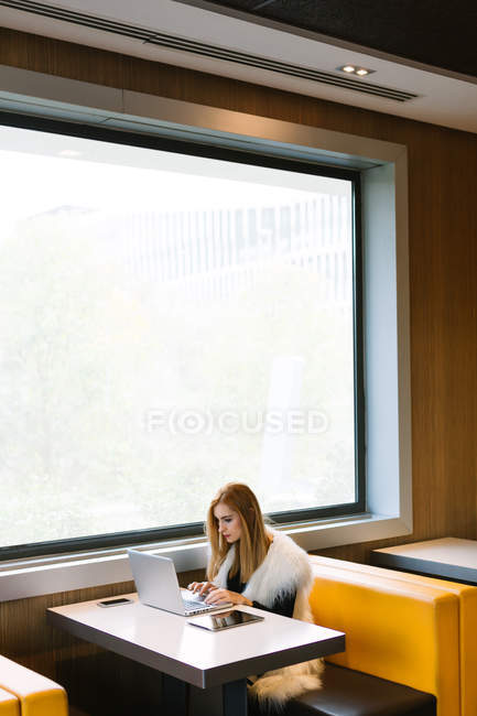 Mulher de negócios bonita que trabalha no café com laptop — Fotografia de Stock
