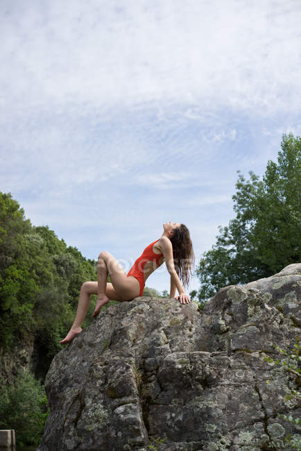 Modèle sensuel en maillot de bain sur roche — Photo de stock