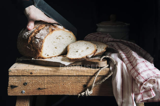 Donna che taglia pane fatto in casa — Foto stock
