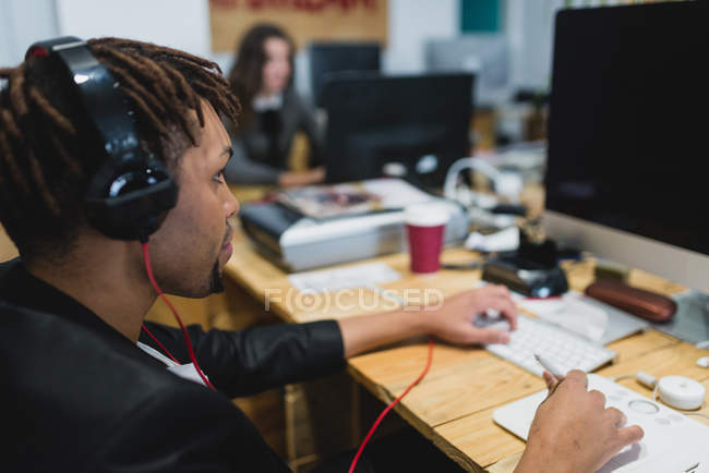 Seitenansicht des Menschen mit Computer mit Grafik-Tablet am Arbeitsplatz — Stockfoto