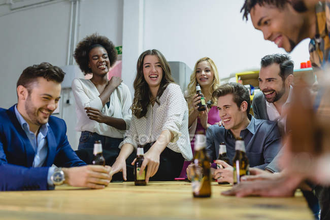 Visão de baixo ângulo de pessoas bebendo cerveja no escritório enquanto a construção de equipe — Fotografia de Stock