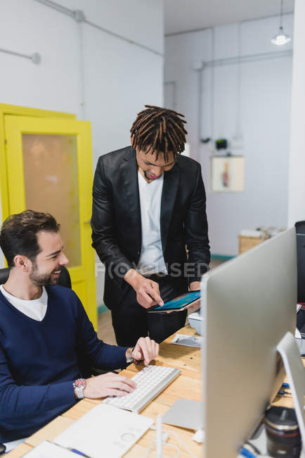 Portrait of colleagues browsing tablet at workplace — Stock Photo