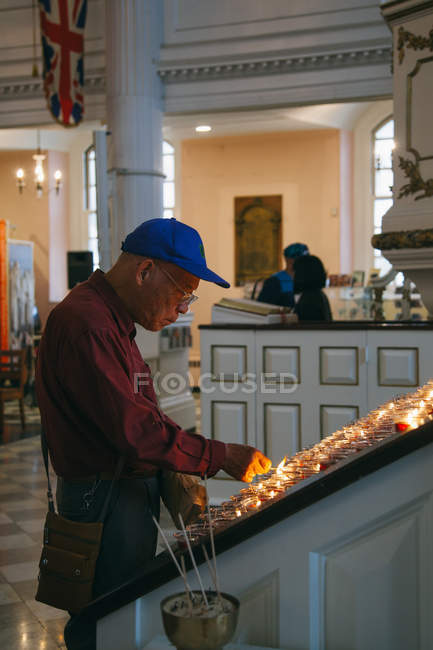 Asian Tourist lighting a candle — Stock Photo