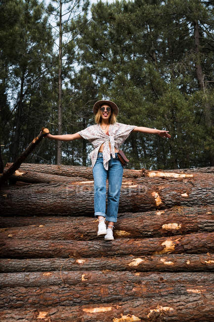 Heureux adolescent debout sur bois bûches — Photo de stock