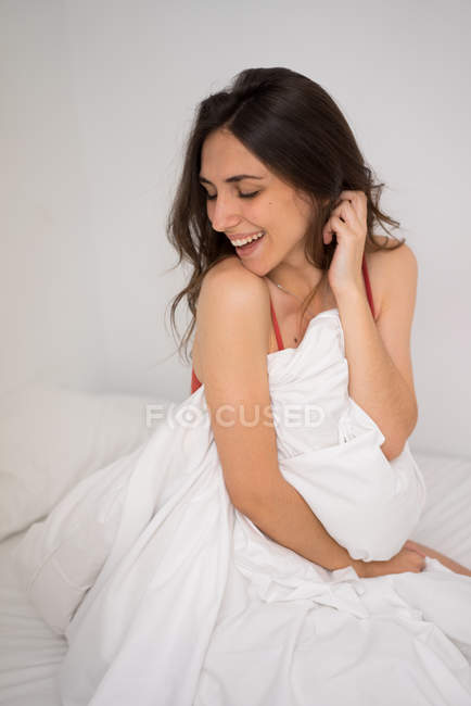Усміхнена ніжна дівчина позує в ліжку — стокове фото