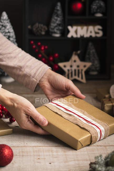 Mujer preparando un regalo para las vacaciones de Navidad - foto de stock