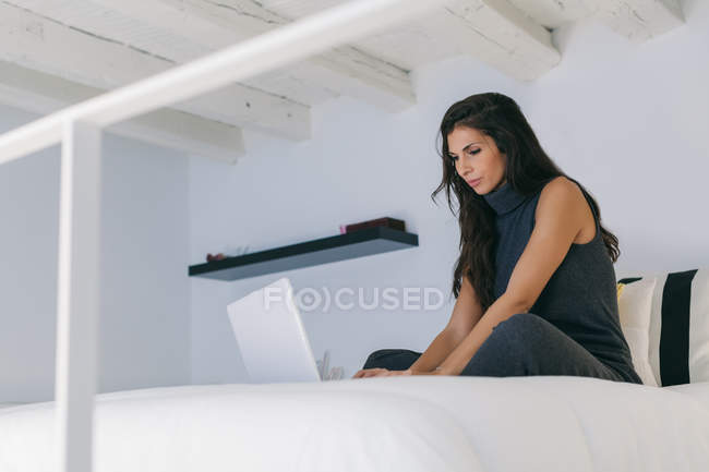 Woman Using a Laptop on Bed — Stock Photo