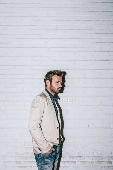 Junger sexy Mann vor einer weißen Backsteinmauer — Stockfoto
