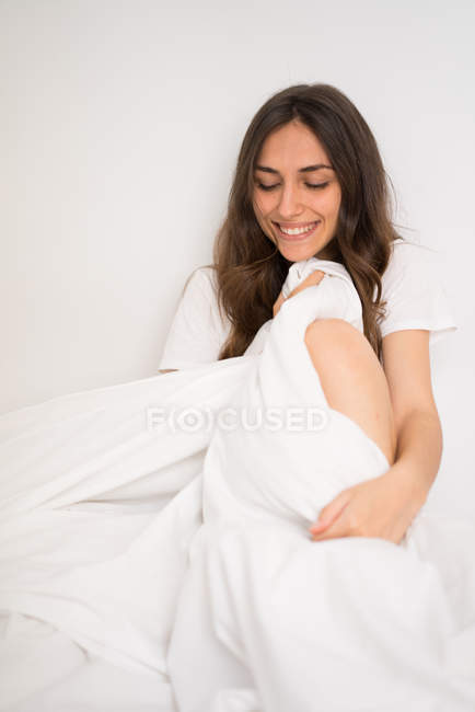 Sorridente ragazza gentile posa a letto — Foto stock