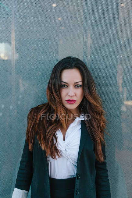 Selbstbewusste Geschäftsfrau posiert gegen metallische Wand — Stockfoto