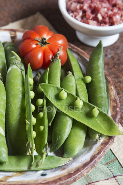 Piselli verdi freschi e crudi con prosciutto — Foto stock