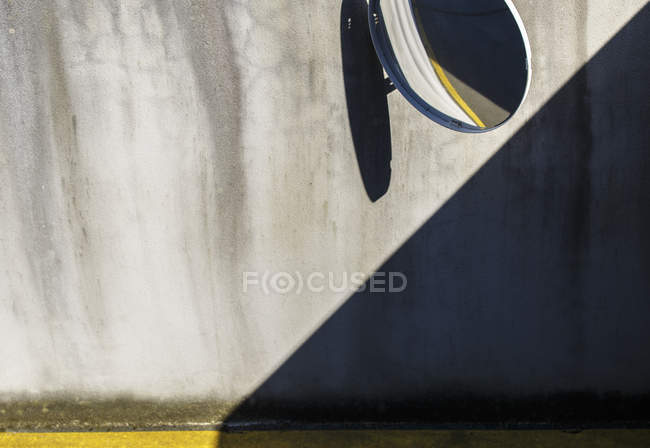 Crop garage mirror and shadow on concrete wall — Stock Photo