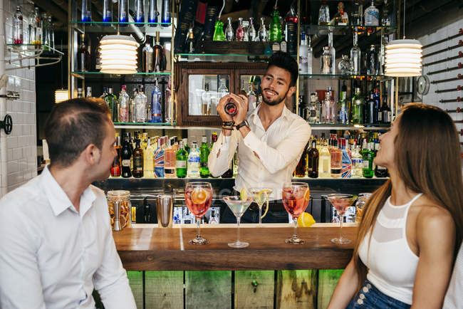 Люди смотрят бармена в баре — стоковое фото