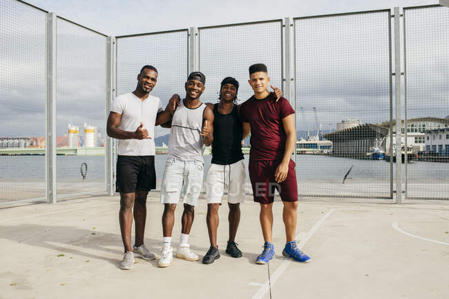 Équipe de basket posant sur le terrain de la rue — Photo de stock