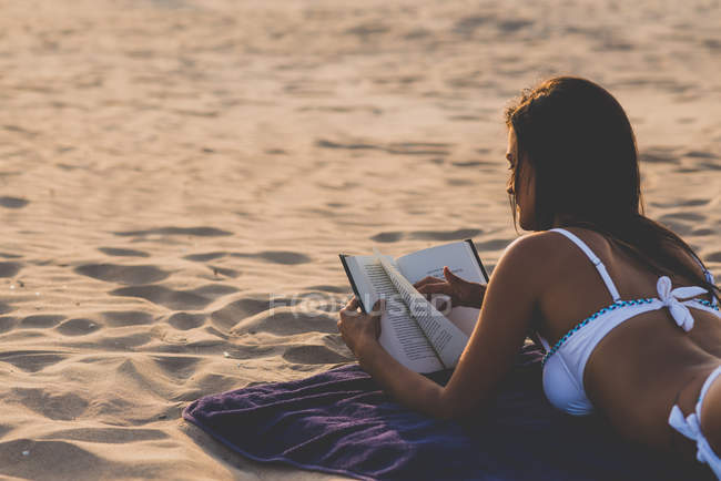 Donna che legge libro in spiaggia — Foto stock