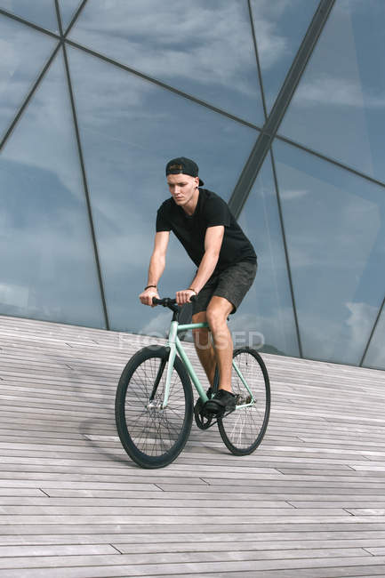 Cher jeune homme en casquette sur vélo — Photo de stock