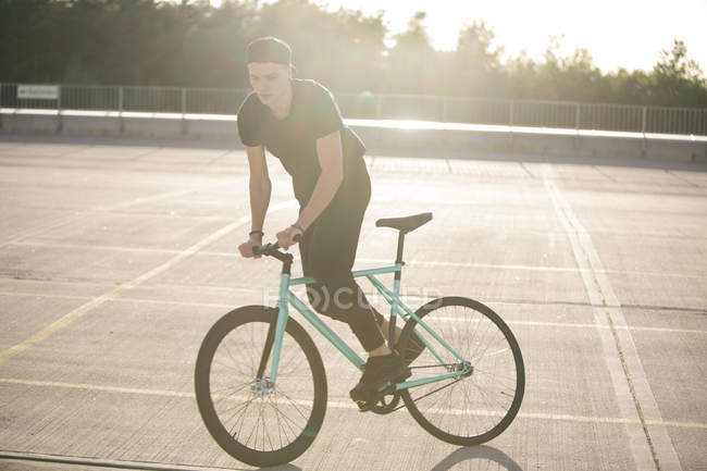 Young man riding bike — Stock Photo