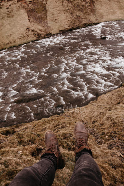 L'uomo sulla roccia con il fiume che scorre sotto — Foto stock