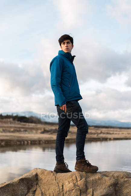 Junger Mann posiert gegen See — Stockfoto