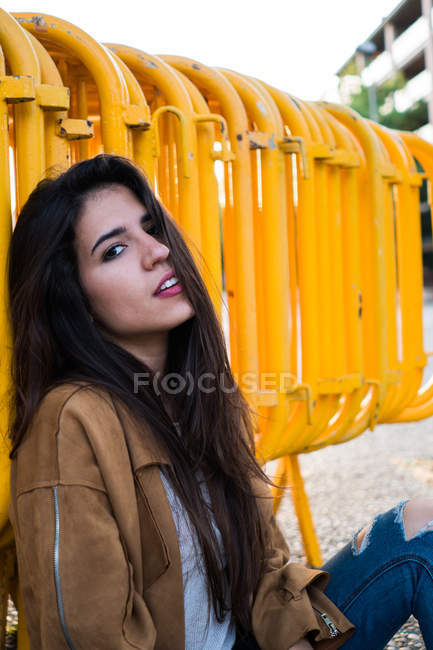 Brunette sitting outside looking pensive. — Stock Photo