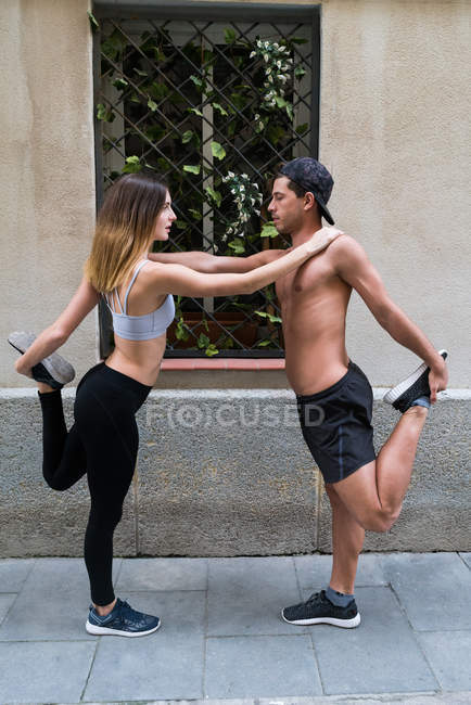 Couple stretching on street — Stock Photo
