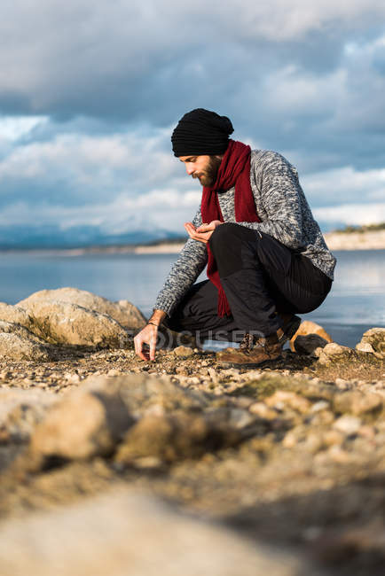 Male explorer collecting pebbles — Stock Photo
